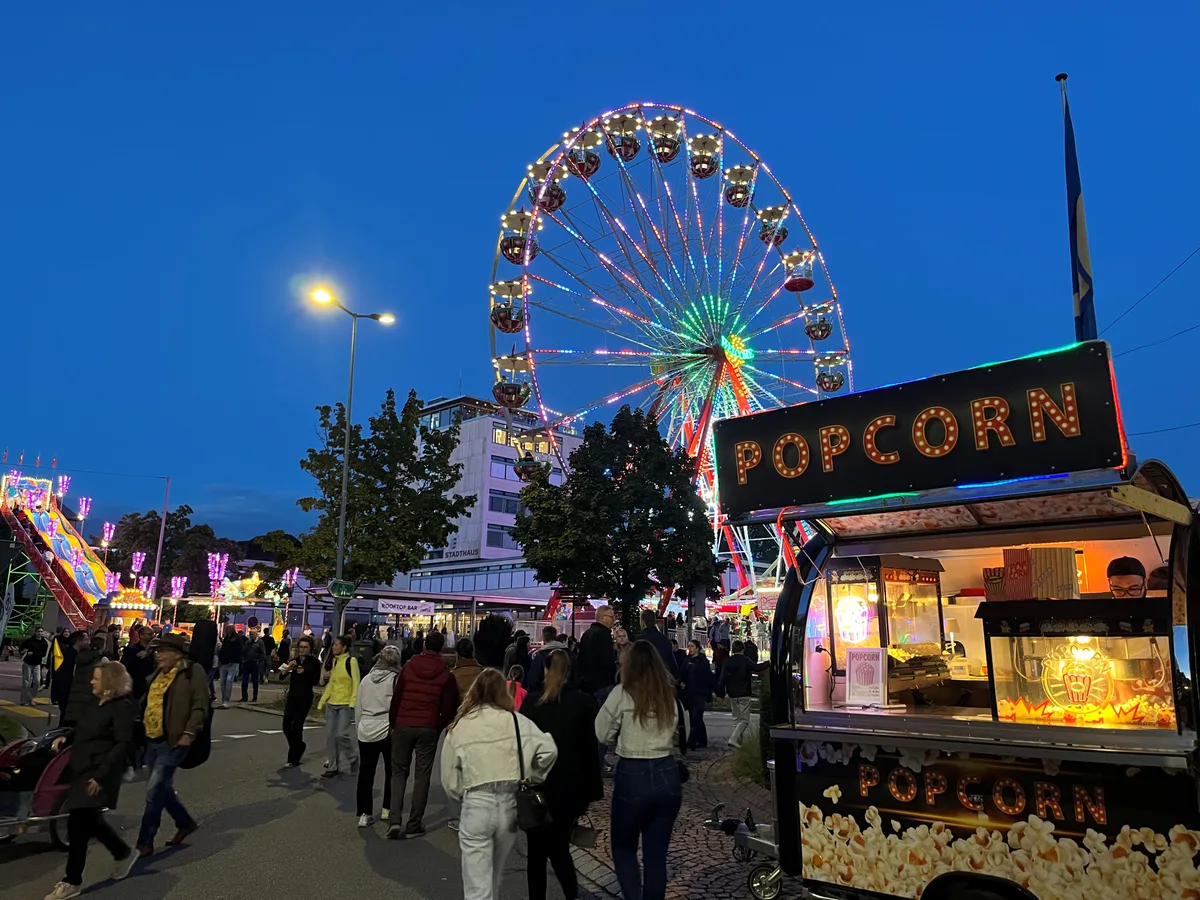 Auch die Chilbibahnen ziehen Gäste an. Ein Popcorn-Stand vor einem Riesenrad.